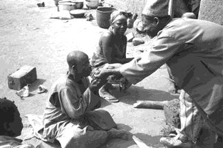 cd1709-30-f213-97a.jpg The widower is treated - here lumps of porridge are held to his lips to taste