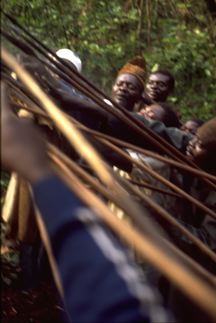 cd1709-10-f217-20.jpg 3. Blowing beer over the spears held by the classifcatory sons of the man whose grave is being treated. The man organising the rite is visible wearing the brown hat